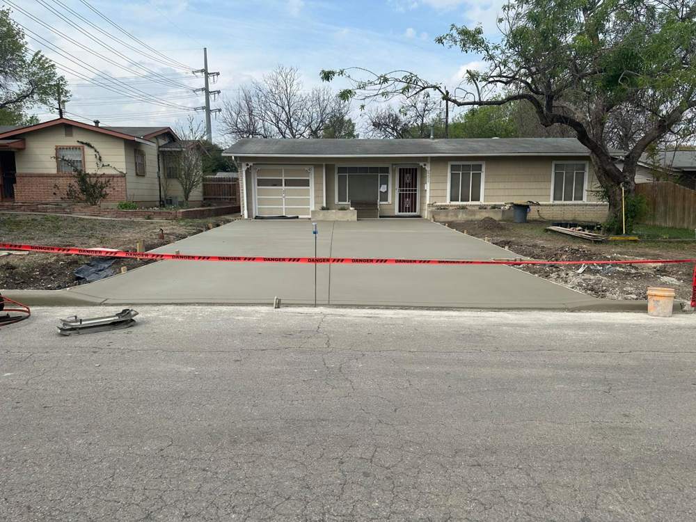 Finished concrete driveway with control joints, taped off to cure