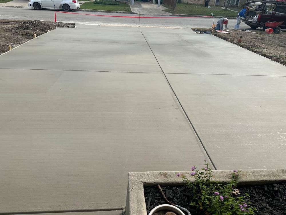 Crew finishing a new two-lane concrete driveway