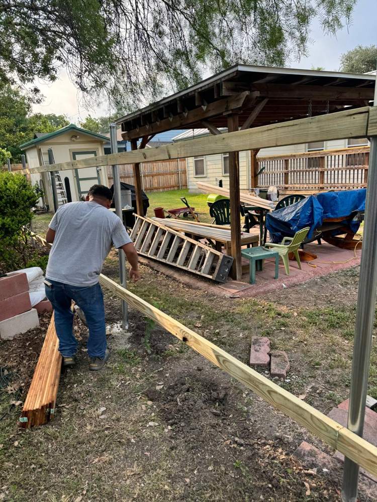 Crew member setting rails on steel fence posts