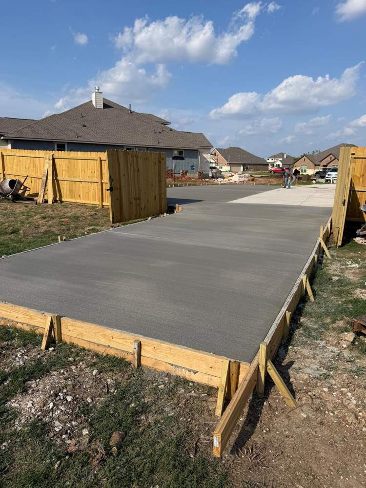 New concrete driveway between freshly built wood privacy fences