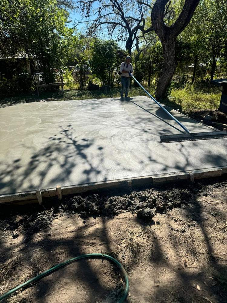 Crew broom-finishing a freshly poured slab